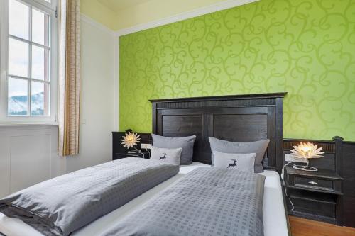 a bedroom with two beds and a green wall at Landhaus Christophorus in Forbach