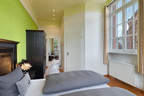 a bedroom with a bed and a green wall at Landhaus Christophorus in Forbach