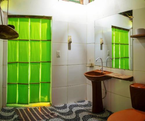 baño con puertas de cristal verde y lavamanos en Reserva Natural PALMARI, en Leticia