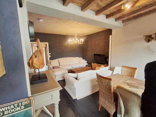 a living room with a white couch and a table at Maison Lucy In het huis van de kunstenares in Staden