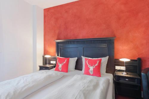 a bedroom with two red pillows on a bed at Landhaus Christophorus in Forbach