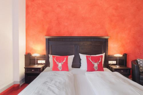 a bedroom with a bed with two red pillows at Landhaus Christophorus in Forbach
