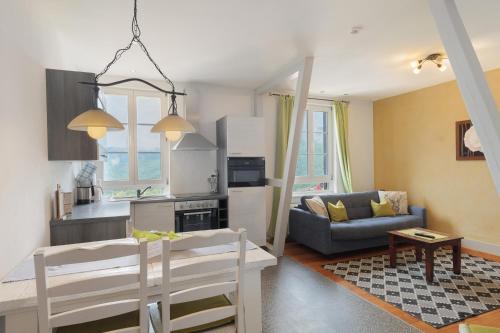 a kitchen and living room with a table and a couch at Landhaus Christophorus in Forbach