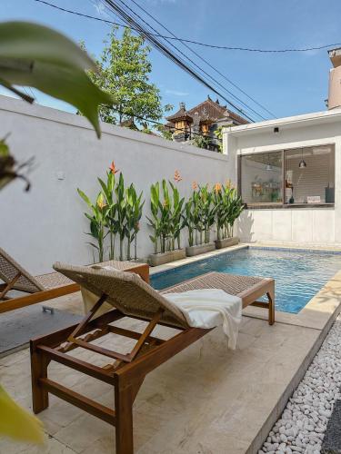 Una piscina con una tumbona y una casa. en Tranquil 2BR Villa with Pool, en Kerobokan