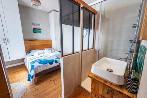 a small bathroom with a sink and a bed at Cosy Primel - Plougasnou in Plougasnou