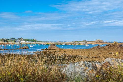 a beach with rocks and boats in the water at Cosy Primel - Plougasnou in Plougasnou