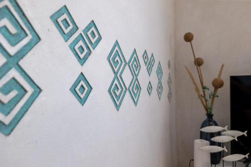 a white wall with blue geometric stencils on it at Cosy Primel - Plougasnou in Plougasnou