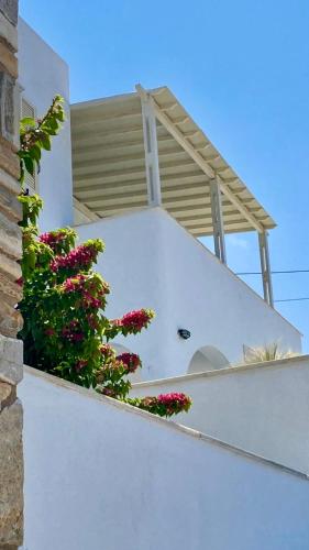a balcony with flowers on the side of a building at Helios Panormos Sea-View Retreat in Nisída Planítis