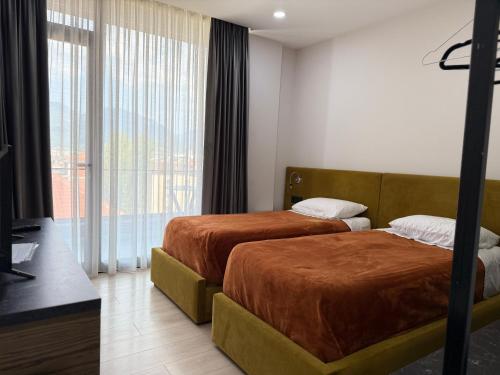 a hotel room with two beds and a large window at Kompleksi Endeta in Bathore
