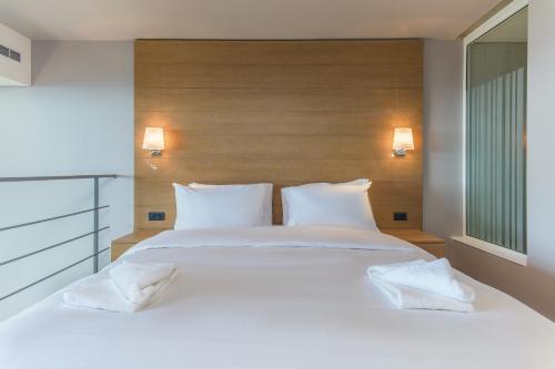 a bedroom with a large white bed with two pillows at Jounieh Living - Residences by Local Host in Ed Dkârîne