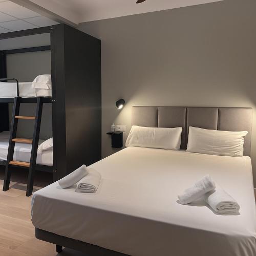 a bedroom with a bed and two bunk beds at H Complutum in Alcalá de Henares