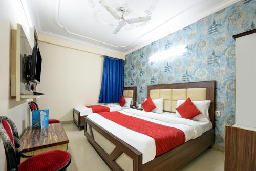 a hotel room with two beds and a tv at Hotel Mayank Plaza At Airport in New Delhi