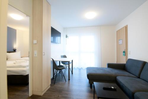 a living room with a couch and a table at Smart & Stay Aparthotel Saarbrücken Süd - Self-Check-In - Free Parking in Saarbrücken