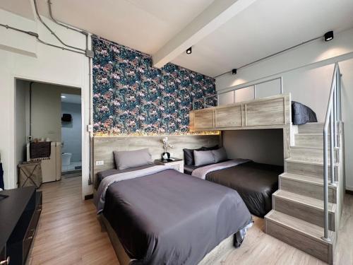 two beds in a room with a bunk bed at FM Ratchada in Ban Na Song