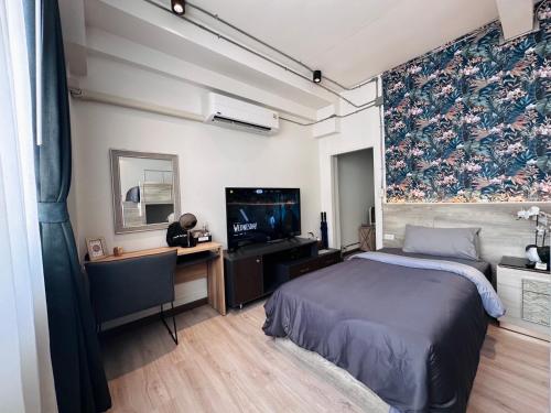 a bedroom with a bed and a desk and a tv at FM Ratchada in Ban Na Song