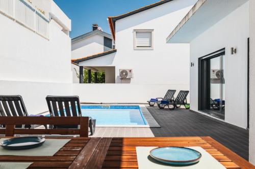 a home with a swimming pool and a patio at Valadares Pool Villa in Corroios