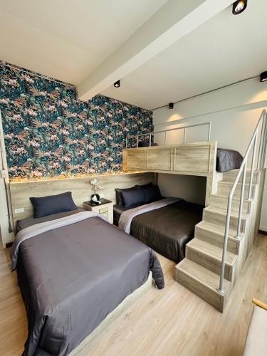 a bedroom with two beds and a stair case at FM Ratchada in Ban Na Song