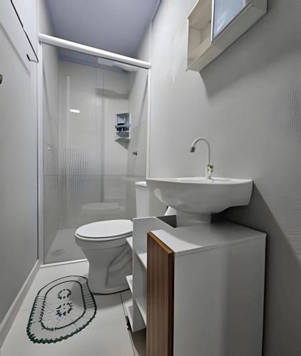 a bathroom with a toilet and a sink and a shower at Studios em Camboriú in Camboriú