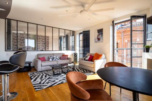 una sala de estar con una mesa y sillas en Capitole Horizon, en Toulouse