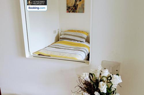 a mirror hanging on a wall with a bed at Spacious 3-Bedroom House Near Leeds City Centre By Homebird Property Management Short Lets & Serviced Accommodation Leeds With En-Suite Bathrooms & Free Parking in Leeds