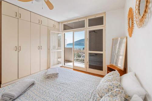 a bedroom with a bed and a view of the ocean at Apartman Zvezda in Igalo