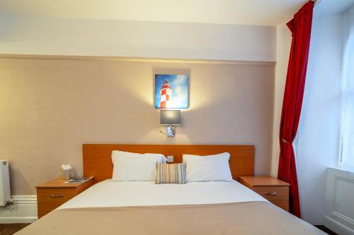 a bedroom with a bed with a red curtain at The Grand Scarborough in Scarborough