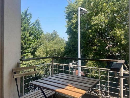 a wooden bench on a balcony with a street light at Relógio Guest House in Porto