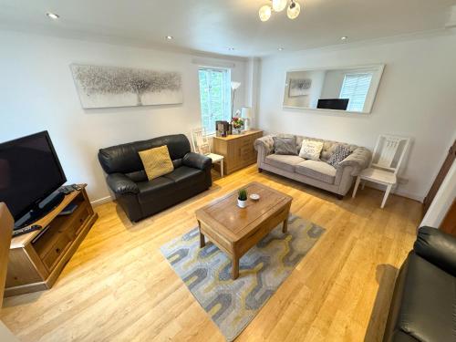 a living room with a couch and a table at Forgemasters House in Telford