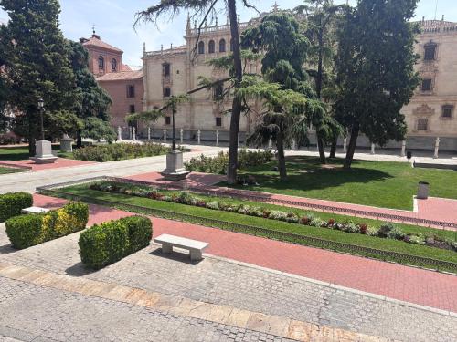 a park with a bench in front of a building at H Complutum in Alcalá de Henares
