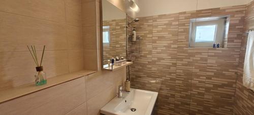 a bathroom with a sink and a shower with a mirror at Apartament 2 camere in Râmnicu Vâlcea