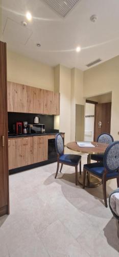 a room with a table and chairs and a kitchen at Résidence Aston la Scala in Nice