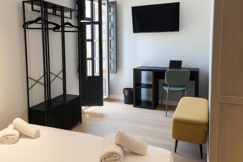 a room with a bed and a desk and a chair at H Complutum in Alcalá de Henares