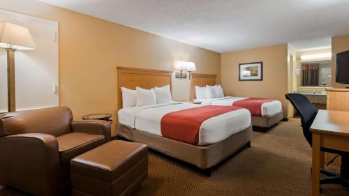a hotel room with two beds and a desk at SureStay Plus by Best Western Covington in Covington