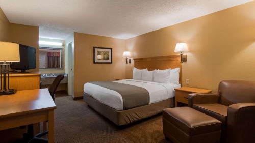 a hotel room with a bed and a desk at SureStay Plus by Best Western Covington in Covington