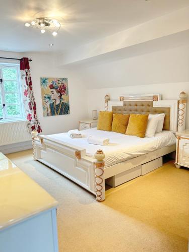 a bedroom with a large white bed with yellow pillows at Forgemasters House in Telford