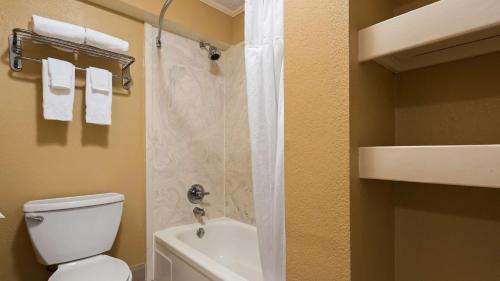 a bathroom with a shower with a toilet and a sink at SureStay Plus by Best Western Covington in Covington