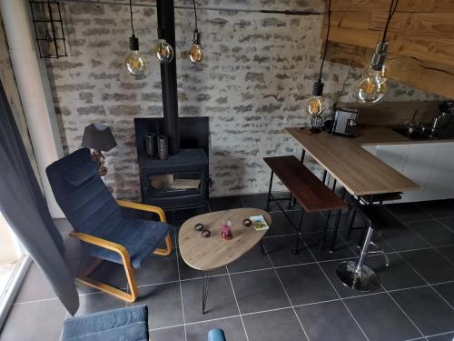 a living room with a table and a stove at Les Gîtes des Chaumes de Villeneuve - Le Loft 