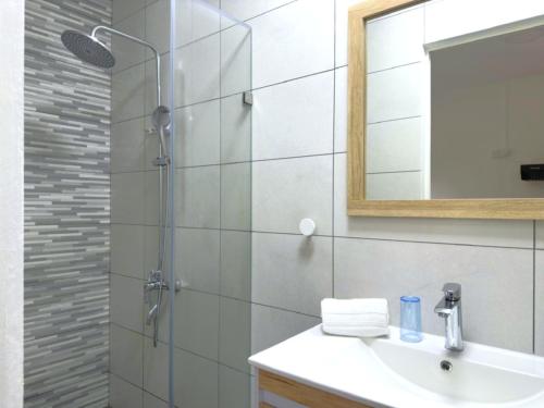 a bathroom with a shower and a sink and a mirror at Residence Le Point Choisy in Pointe aux Cannoniers