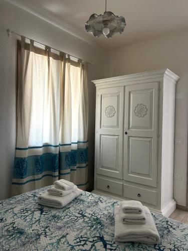 a bedroom with a bed with two towels on it at Appartamento Gaia in Santa Maria Navarrese