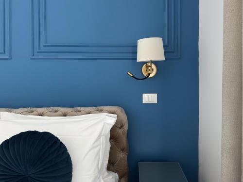 a blue bedroom with a white pillow and a lamp at Alto Apartment in Rome