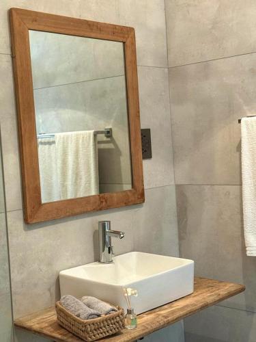 a bathroom with a white sink and a mirror at La Mera Ocean-View, with Pool and 2 stylish Bedroom in Shanzu