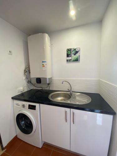 a bathroom with a sink and a washing machine at Atlantic Breeze House in Corralejo