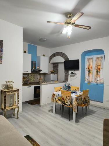a living room with a dining table and a ceiling fan at Monolocale in vicolo storico Gin Tonic Lemon in Rodi Garganico