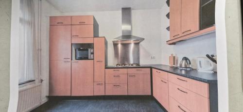 a kitchen with wooden cabinets and a stove at Tower Apartment Centre Sittard in Sittard
