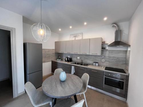 a kitchen with a table and a kitchen with a refrigerator at La Casetta in Bussolengo