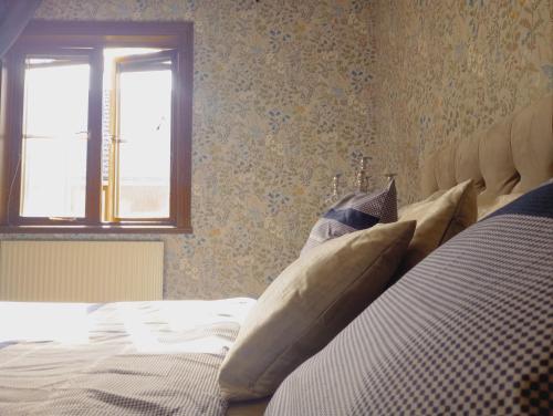 a bedroom with a bed with pillows and a window at Cozy Forest View Villa with 5 Bedrooms in Jönköping