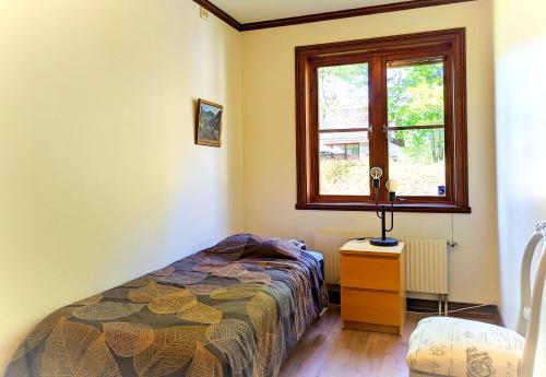 a bedroom with a bed and a window at Cozy Forest View Villa with 5 Bedrooms in Jönköping