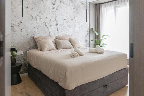 a bedroom with a large bed with towels on it at Panorama Prestige by Elite Apartments in Starogard Gdański