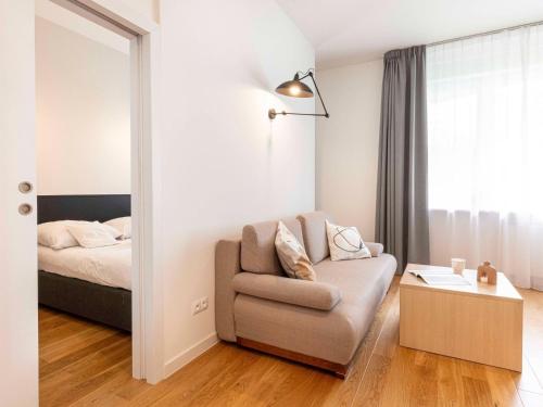 a living room with a couch and a bed at Apartamenty Media Park in Warsaw