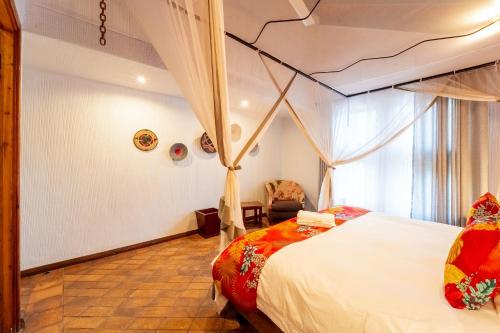 a bedroom with a bed and a chair at Kasongo Lodge in Victoria Falls